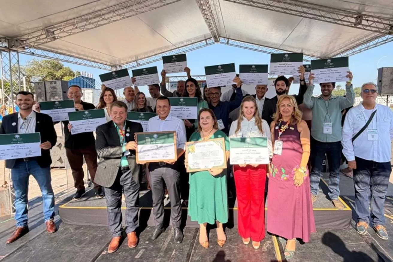 A diverse group of individuals proudly displaying their certificates in a celebratory setting.
